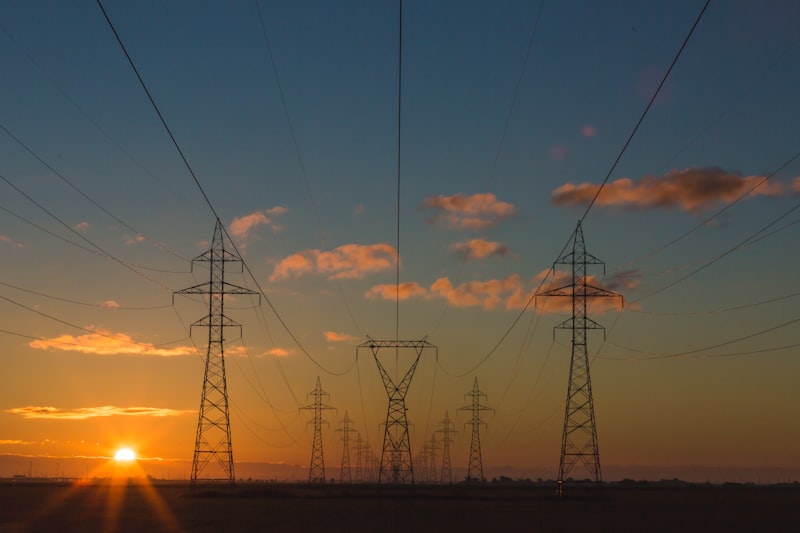 Electricity transmission towers at sunset — Australian energy sales